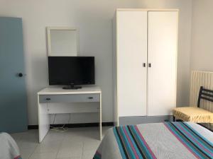 a bedroom with a tv on a dresser with a bed at Hotel Lo Zodiaco in Oppido Lucano