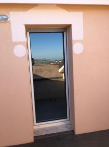 een raam in een muur met uitzicht op een gebouw bij Hotel Lo Zodiaco in Oppido Lucano