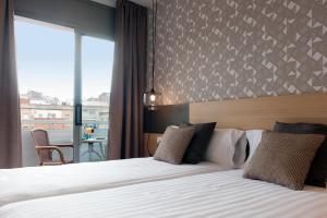 a hotel room with a large bed and a balcony at AB Sagrada Familia Premium in Barcelona