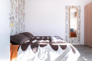 a bedroom with a black and white bed with a mirror at Fonda Chavarria in Sant Joan Despí