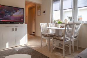 a living room with a table and chairs and a tv at DC Executive Homes in Novi Sad