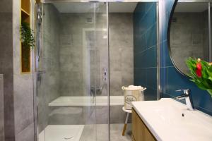 a bathroom with a shower and a sink and a tub at Apartamenty Bohaterów Kragujewca 6 in Bydgoszcz +58 photos