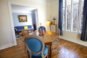 a living room with a table and chairs and a couch at Nice apartment 10 minutes from Paris in Meudon