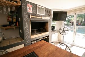 a living room with a fireplace with a table and a television at Lovely Family Home in Durbanville in Durbanville