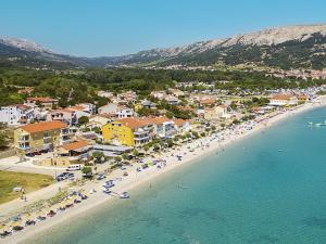 an aerial view of a beach with chairs and umbrellas at Apartments Capic in Baška