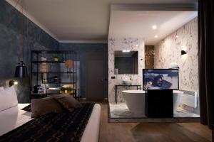 a bathroom with a tub and a tv in a room at Hotel Zuid in Genk