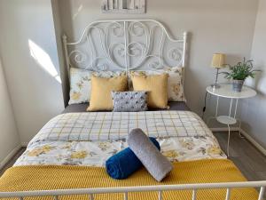 a bedroom with a bed with yellow and blue pillows at Eskdaill Place Apartment in Kettering