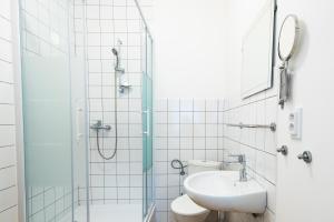 y baño con ducha, aseo y lavamanos. en Slavia penzion, en Mikulov