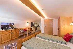 1 dormitorio con 1 cama y TV en una habitación en Hagerhof en Walchsee