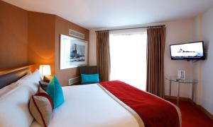 une chambre d'hôtel avec un lit et une télévision dans l'établissement Bermondsey Square Hotel - A Bespoke Hotel, à Londres