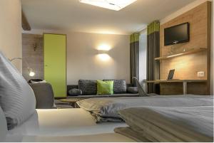 a hotel room with two beds and a couch at Landgasthof Zur Sonne in Fünfstetten +12 photos