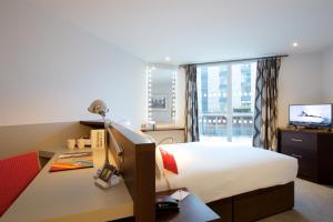 una camera d'albergo con letto e scrivania con computer di Bermondsey Square Hotel - A Bespoke Hotel a Londra