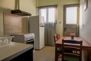 a kitchen with a table and a refrigerator at Lak Peristeri Homes in Athens