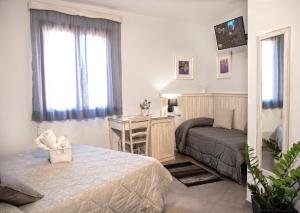 1 dormitorio con cama y escritorio. en Bed & Breakfasts Conte Perollo, en Sciacca