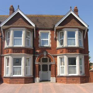 duży ceglany dom z niebieskimi drzwiami w obiekcie Stavordale House w mieście Weymouth
