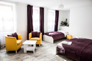 ein Hotelzimmer mit 2 Betten und 2 Stühlen in der Unterkunft Rezidence Černý medvěd in Znojmo