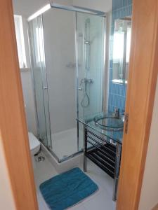 a bathroom with a glass shower and a toilet at Apartamento Ria Formosa no Mar in Fuzeta