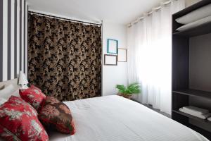 a bedroom with a white bed with red pillows at Laguna Boutique Apartments in Mestre +56 photos