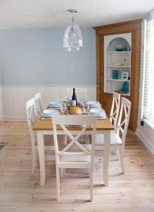 a white dining room table with white chairs and a white dining room at Spencer House in Sandwich