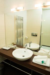 a bathroom with two sinks and a mirror at Hotel Beyfin in Cluj-Napoca