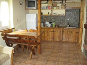 a kitchen with a wooden table and a refrigerator at Domek całoroczny El Coyote in Hoczew