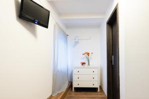 a room with a television on a wall with a dresser at Slavia penzion in Mikulov