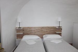two beds in a room with two lamps on the wall at Le Tartarughe Boutique Apartment in Rome