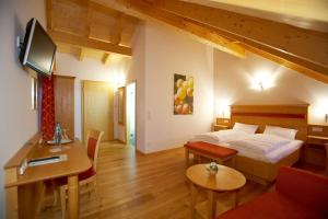 a bedroom with a bed and a living room at Dohlmühle Landhotel & Restaurant in Flonheim +24 photos