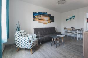 Una sala de estar con un sofá, una silla y una mesa. en La Chalana, en Corralejo