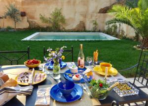 a table with blue plates of food and a swimming pool at XIXe Provencal Stone House with Private Pool near Uzes in Uzès