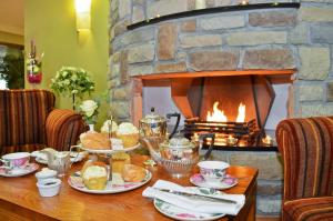 a table with plates of food and a fireplace at Broadhaven Bay Hotel in Belmullet