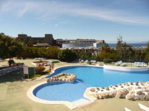a large swimming pool with chairs and umbrellas at Studio Gio - Paraiso del Sur in Playa Paraiso