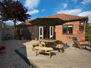 a patio with a picnic table and an umbrella at The Hamlet in Cromer