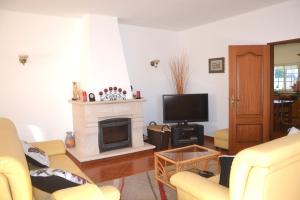Il comprend un salon avec une cheminée et une télévision. dans l'établissement Villa Barros by GalanteVasques, à Carvoeiro