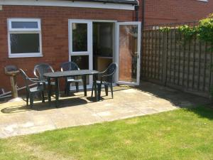 a patio with a table and chairs and a fence at Stavordale House in Weymouth