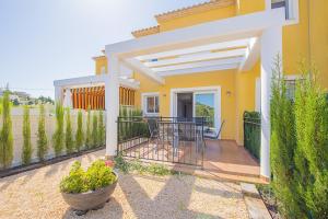 a patio of a yellow house with a pergola at Bungalow Edyta - Plusholidays in Calpe