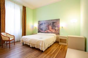 モンテカティーニ・テルメにあるスマート ホテル バルトリーニのベッドルーム1室(ベッド1台付)が備わります。壁には絵画が飾られています。