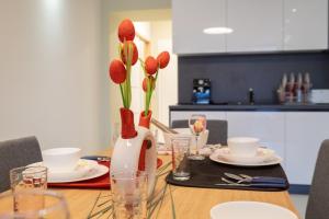 a dining room table with a vase with flowers in it at Vitosha Blvd Luxury 2-Bedroom, 2-Bathroom with Balcony in Sofia