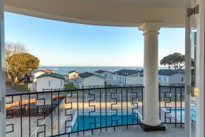 a balcony with a view of a pool and buildings at Sandhills Apartments, Mudeford in Christchurch