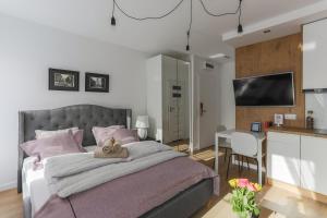 a bedroom with a bed and a table and a kitchen at Central Apartments Piwna in Gdańsk