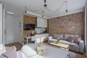 a living room with a couch and a brick wall at Central Apartments Piwna in Gdańsk
