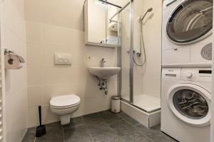 a bathroom with a toilet sink and a washing machine at Yellow Flat by GrazRentals with best location & free parking in Graz