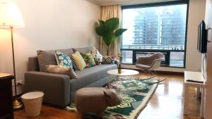 a living room with a couch and a large window at Artistic Studio in Taichung