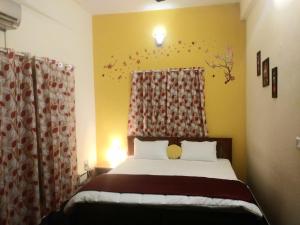 1 dormitorio con 1 cama y una ventana con cortinas en ROYALE ACHAYA en Chennai