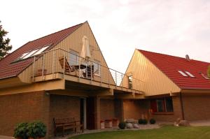 a house with a balcony on top of it at Landhaus Tönning in Damp