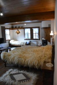 een groot bed met een grote vacht bij Къща за гости Гайтана in Shiroka Lŭka