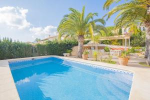 a swimming pool in a yard with palm trees at Villa Gran Sol in Calpe