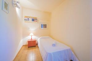 a small bedroom with a bed and a table with a lamp at Villa Gran Sol in Calpe