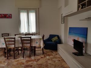 ein Wohnzimmer mit einem Tisch und Stühlen sowie einem TV in der Unterkunft Rita's House in Monterosso in Monterosso al Mare