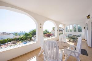 a room with white chairs and a table on a balcony at Villa Roel in Calpe